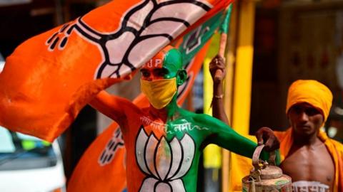 Supporters of Bharatiya Janata Party (BJP) wave party flags as they arrive a day before the groundbreaking ceremony of the proposed Ram Temple, in Ayodhya on August 4, 2020.