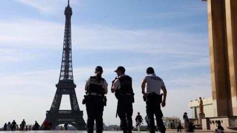 Three French policemen patrol on the Esplanade du Trocadero in front on the Eiffel Tower in Paris, on July 3, 2019.