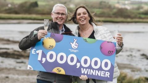 Sue and Neil Smart with '£1,000,000 winner' banner