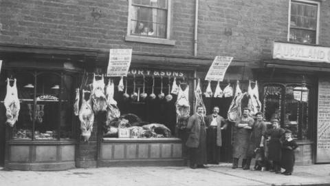 Old photo of meat and people outside shop
