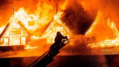 A firefighter extinguishes a fire at Kandawgyi Palace hotel in Yangon early on 19 October 2017