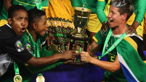 Andile Dlamini, Refiloe Jane and Janine van Wyk lift the Women's Africa Cup of Nations trophy for South Africa