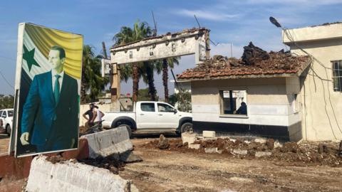 A poster of Syrian President Bashar al-Assad is seen at a site reportedly damaged in an Israeli strike, in Hama, central Syria (9 September 2024)