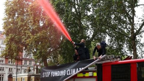 Extinction Rebellion protesters spray red water at the Treasury