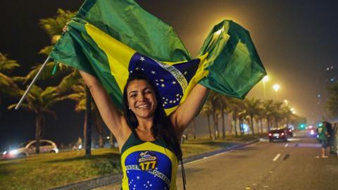 A supporter of Jair Bolsonaro in Brazil celebrates his first round win, dressed up in the flag, October 7 2018