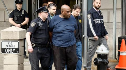 Frank James is escorted out officers after his arrest in Brooklyn