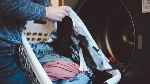 Person washing clothes in machine