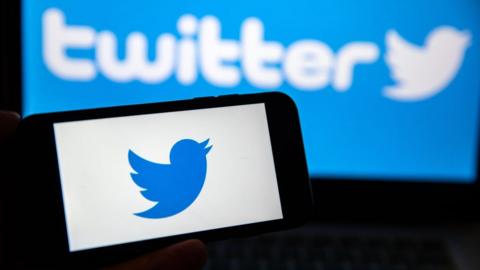 A twitter logo shown on a screen