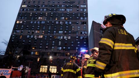 Emergency personnel from the New York City Fire Department (FDNY) respond to an apartment building fire in the Bronx borough of New York City, on 9 January 2022