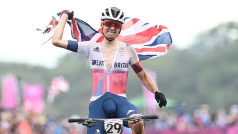 Tom Pidcock celebrating winning an Olympic gold medal in 2021