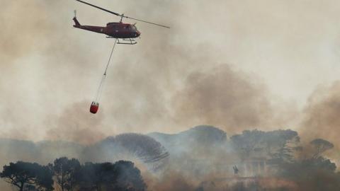 Helicopter drops water on fire