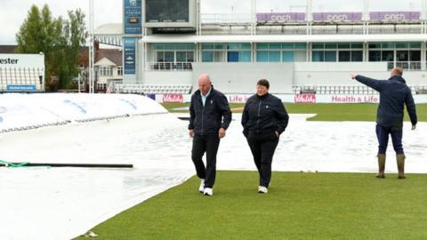 Umpires inspect the wet field at Wantage Road