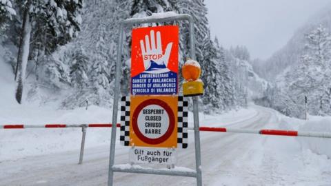 A sign warning of avalanche danger is seen on a closed road after heavy snowfall near Obertauern, Austria