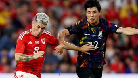 Harry Wilson of Wales is challenged by Young-Woo Seol