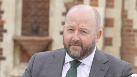 Nick Timothy is pictured wearing a grey suit and green tie