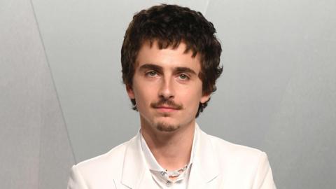 Timothée Chalamet pictured last month wearing a white shirt and white suit.