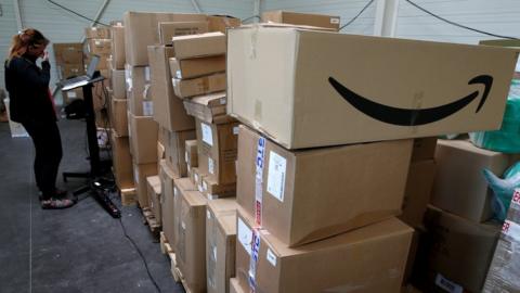 An employee prepares an order for Amazon at Porona warehouse in Bruay-sur-l'Escaut near Valenciennes, France, April 22, 2020