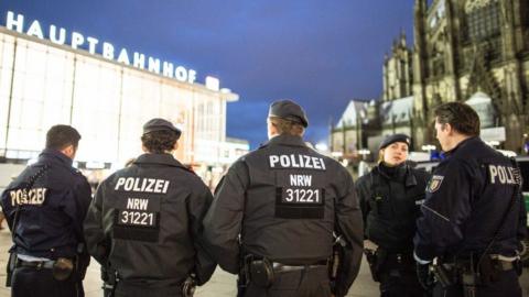 Police officers stand outside the main station in Cologne