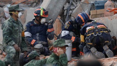 Rescue workers search through rubble of Enrique Rébsamen school