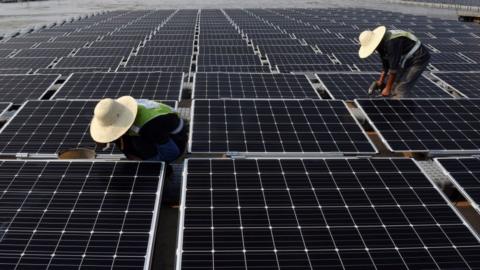 workers at the world's largest floating solar power plant in a lake in Huainan