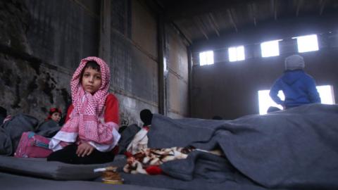 Syrians, who fled from rebel-held areas in the city of Aleppo, are seen on November 30, 2016, at a shelter in the neighberhood of Jibrin, east of Aleppo.