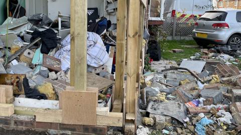 Debris after car crashes into house