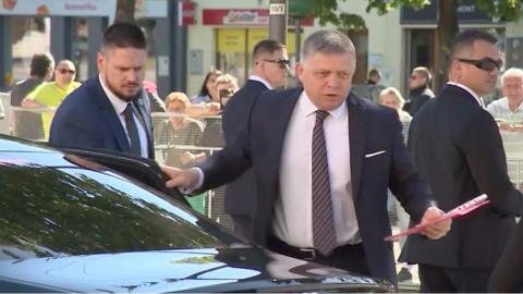 Slovak PM Fico next to car surrounded by security agents