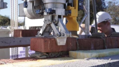 A robot laying a brick
