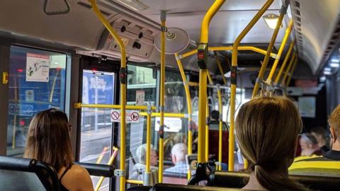Three people sat on a bus