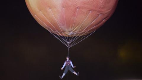 Saturday's festivities culminated in a performer being suspended from a giant peach