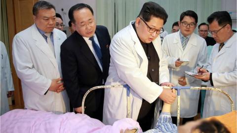 This April 23, 2018 picture released by North Korea"s official Korean Central News Agency (KCNA) on April 24, 2018 shows North Korean leader Kim Jong-Un (C) speaking to an injured Chinese tourist at a hospital during a visit with Chinese Ambassador to North Korea Li Jinjun (L), at an undisclosed location in North Korea.