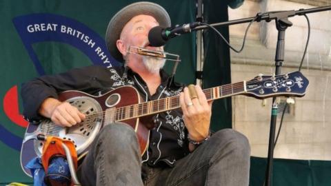 Busker playing instrument at music festival