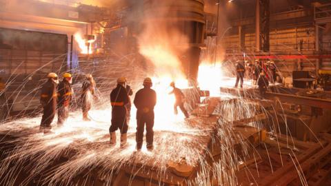 Workers with molten steel in a factory.