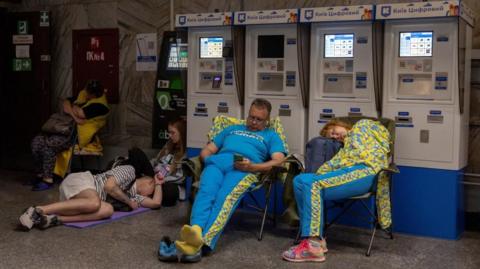 People take shelter in a metro station during Russian drone and missile strikes in Kyiv