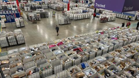 A bird's eye view of a mail delivery centre, with lots of cages full of post