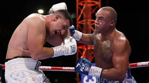 Justis Huni covers up as Fabio Wardley punches him