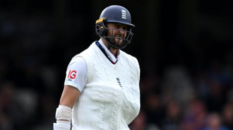 Chris Woakes with his injured shoulder inside his England jumper when he came out to bat at the Oval