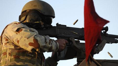 An unidentified Australian soldier test fires a gun