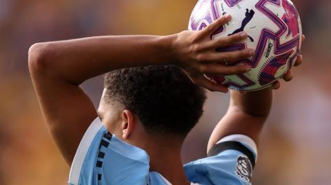 Back of Rico Lewis taking a throw in for Manchester City