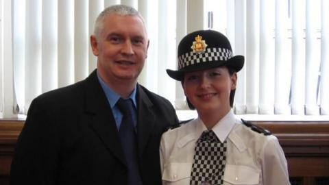 Bryn Hughes stands and smiles for a photograph with his daughter Nicola. She is wearing police uniform.