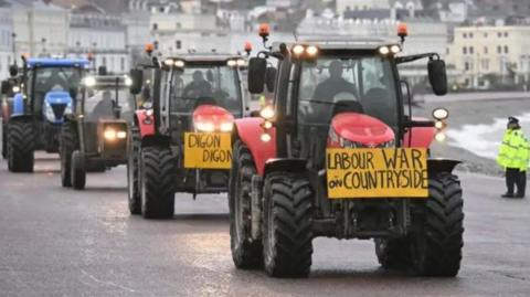 A convoy of tractors along the promenade in Llandudno 