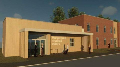 An artist's impression of the new surgery. It shows a smaller, single-storey building with a large entrance and the words 'Hucclecote Medical Centre' on the front, next to several two-storey buildings. 