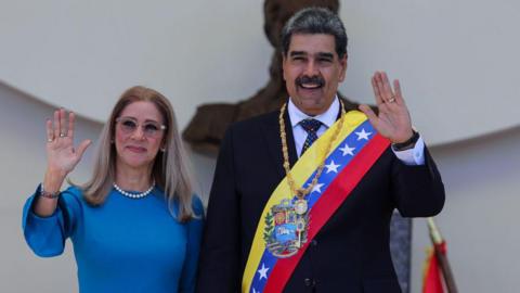 Flores and Maduro waving to a crowd