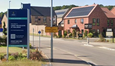 A new build housing estate with a navy blue sign that has "Crest Nicholson at Malabar" written on it.