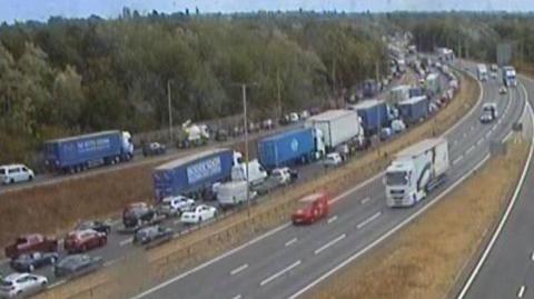 A still from a traffic camera showing large queues of cars and lorries on the A14.