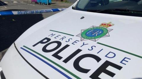 A white van with the Merseyside Police writing and logo