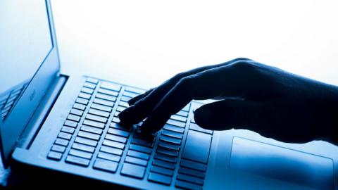 Close up of a hand on a laptop keyboard