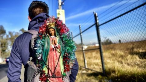 Man carries an image of the Virgin of Guadalupe in Amecameca, Mexico state, 11 December 2017