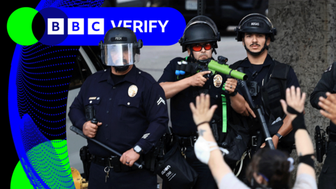 Police officers in LA face protesters holding their arms up