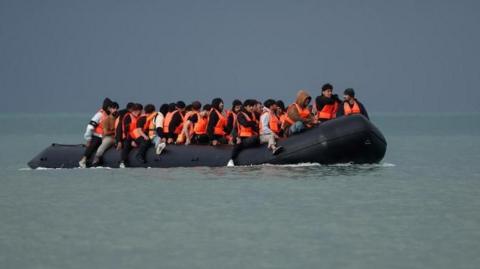 An inflatable dinghy carrying migrants crosses the English Channel